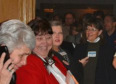 Elaine Miller, past president, is giddy with delight as she passes out tee shirts, software and books.